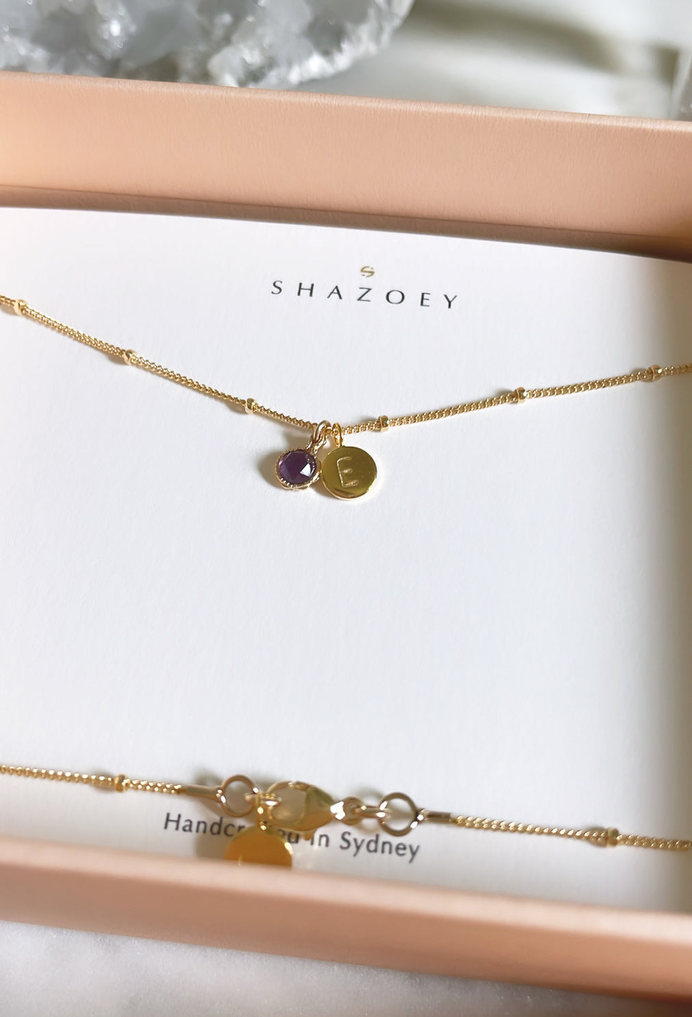 February birthstone necklace with a sparkly amethyst gemstone and initial pendant displayed in a gift box