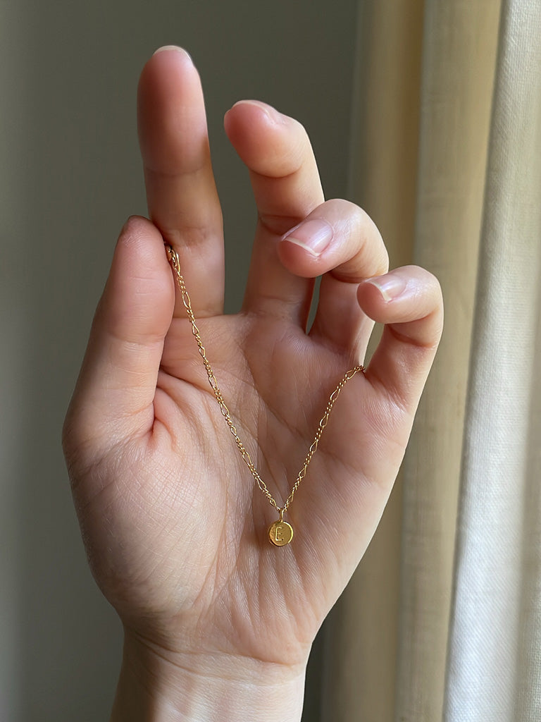 Personalised gold necklace with initial pendant and 14k gold filled figaro chain on hand