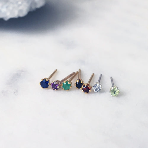 Tiny gemstone stud earrings set with blue sapphire, amethyst, emerald, red garnet, white topaz and peridot