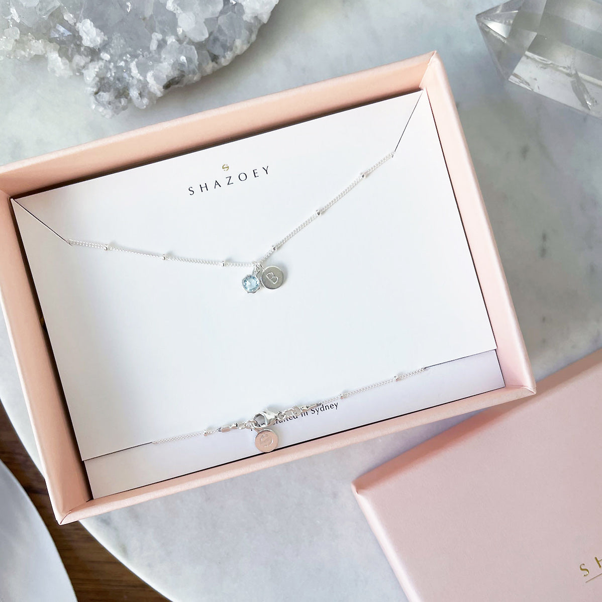 Aquamarine birthstone necklace with initial pendant and sterling silver chain in jewellery gift packaging