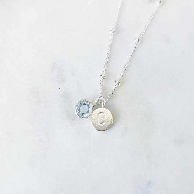Aquamarine birthstone necklace in sterling silver personalised with an initial pendant
