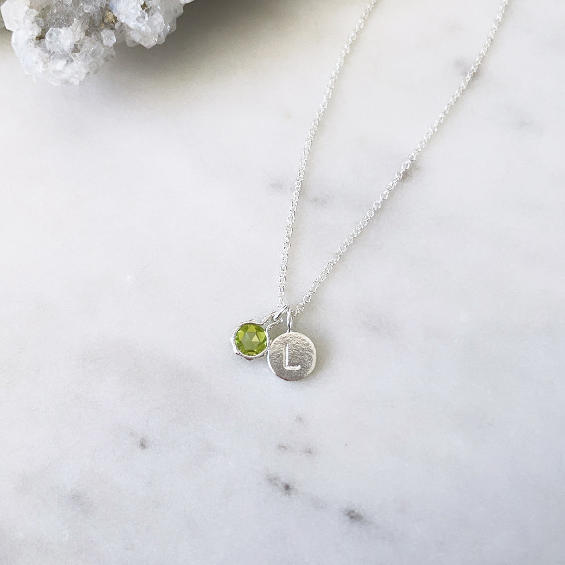 August birthstone necklace with green peridot pendant and an initial pendant in sterling silver