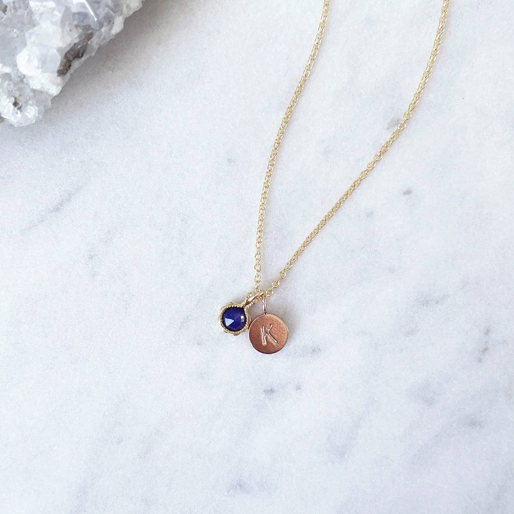 September birthstone necklace with blue sapphire and a rose gold letter initial pendant