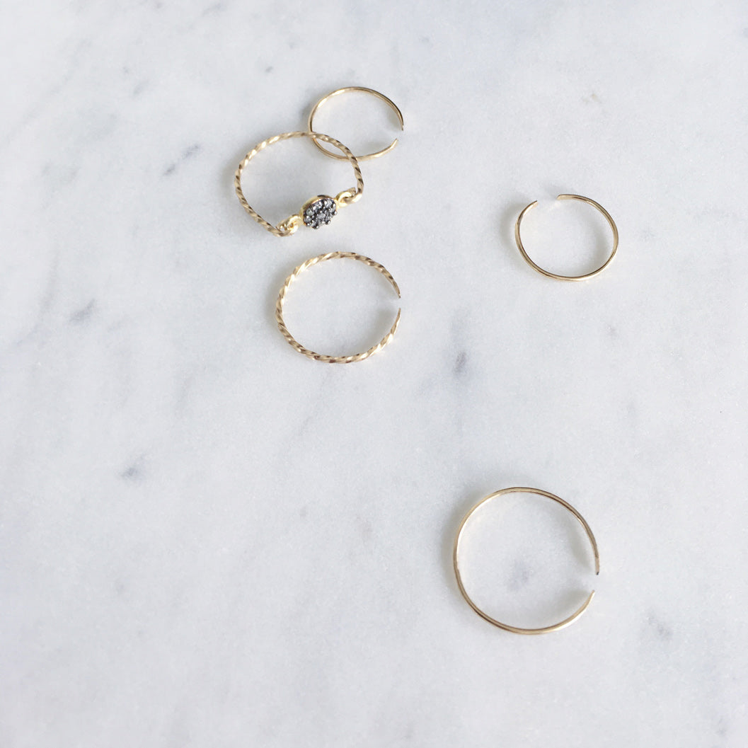 Collection of fine gold rings, one with pavé set rough diamonds and dainty gold filled rings with a twisted and hammered finish
