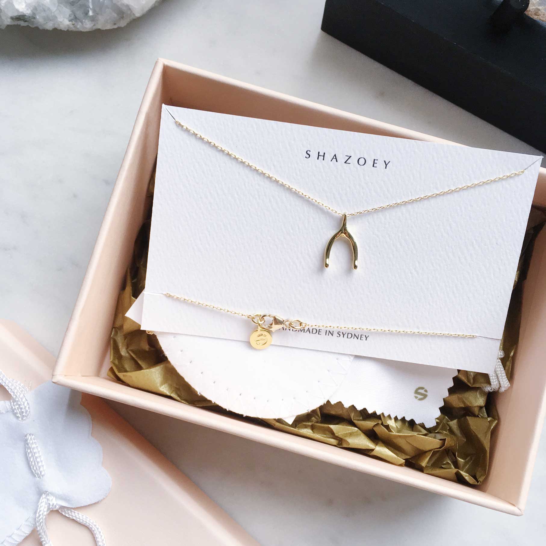 Dainty necklaces in gold and sterling silver such as our minimalist wishbone necklace in gift packaginf