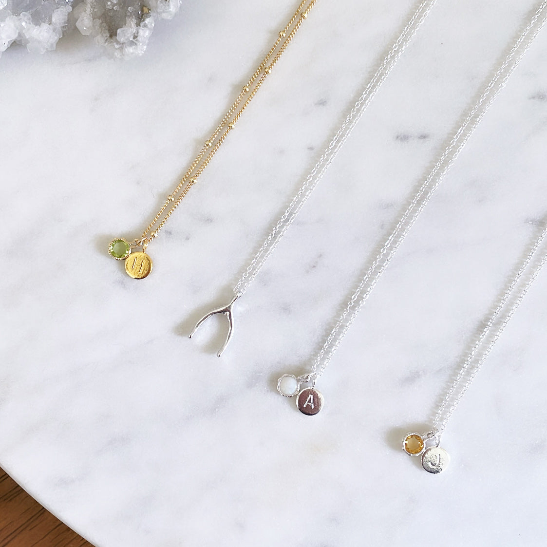 Dainty minimalist birthstone necklaces with personalised initial pendants and a sterling silver wishbone necklace, jewellery handmade in Sydney Australia