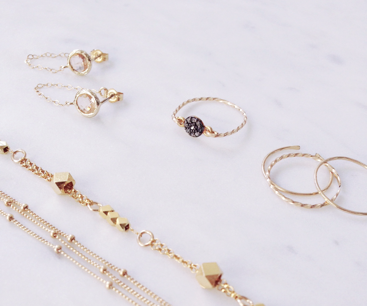 Gold minimalist jewellery handmade in Sydney Australia showing dainty gold stacking rings, gold chains and bracelets.