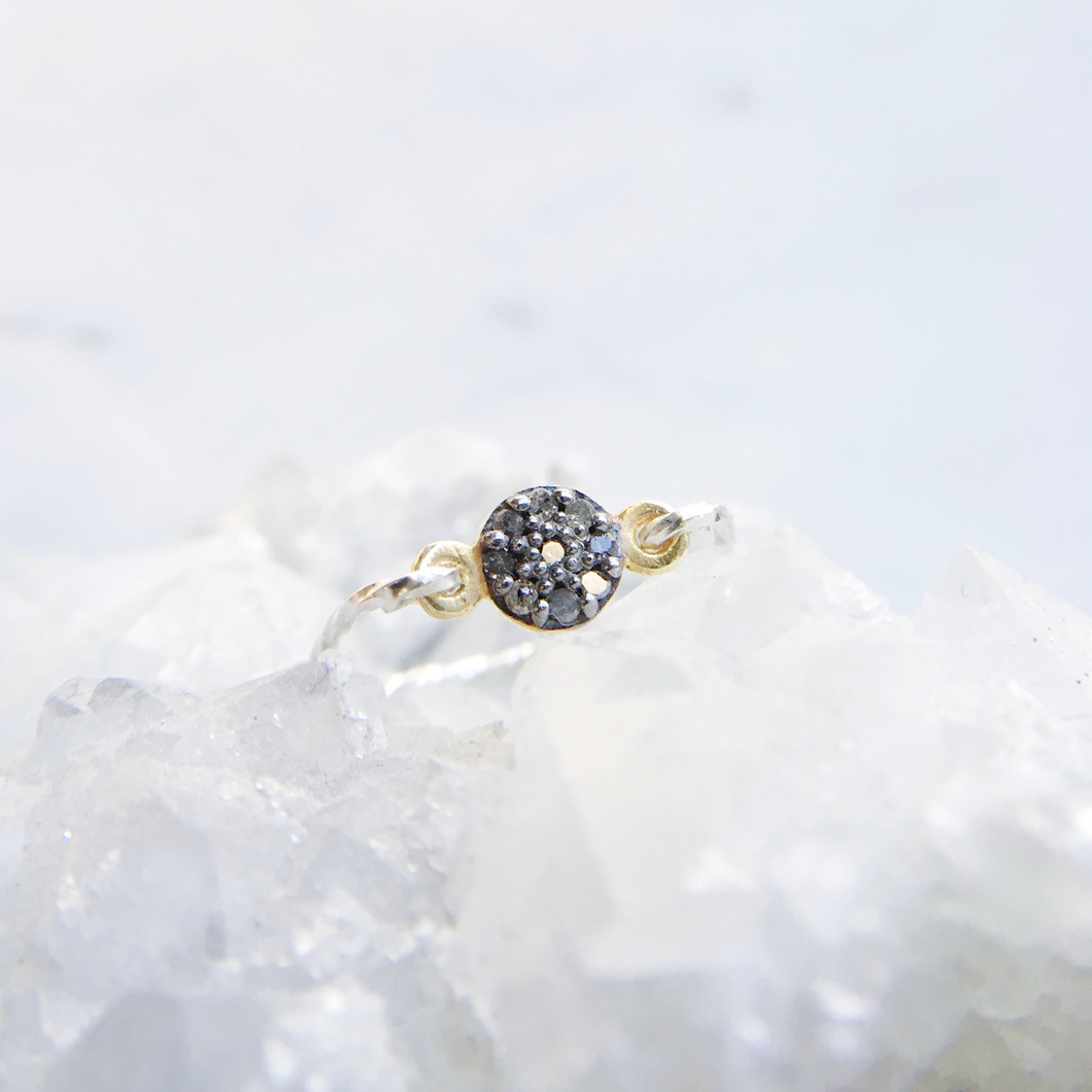 Modern diamond ring with small rough pavé diamonds with a twisted sterling silver band
