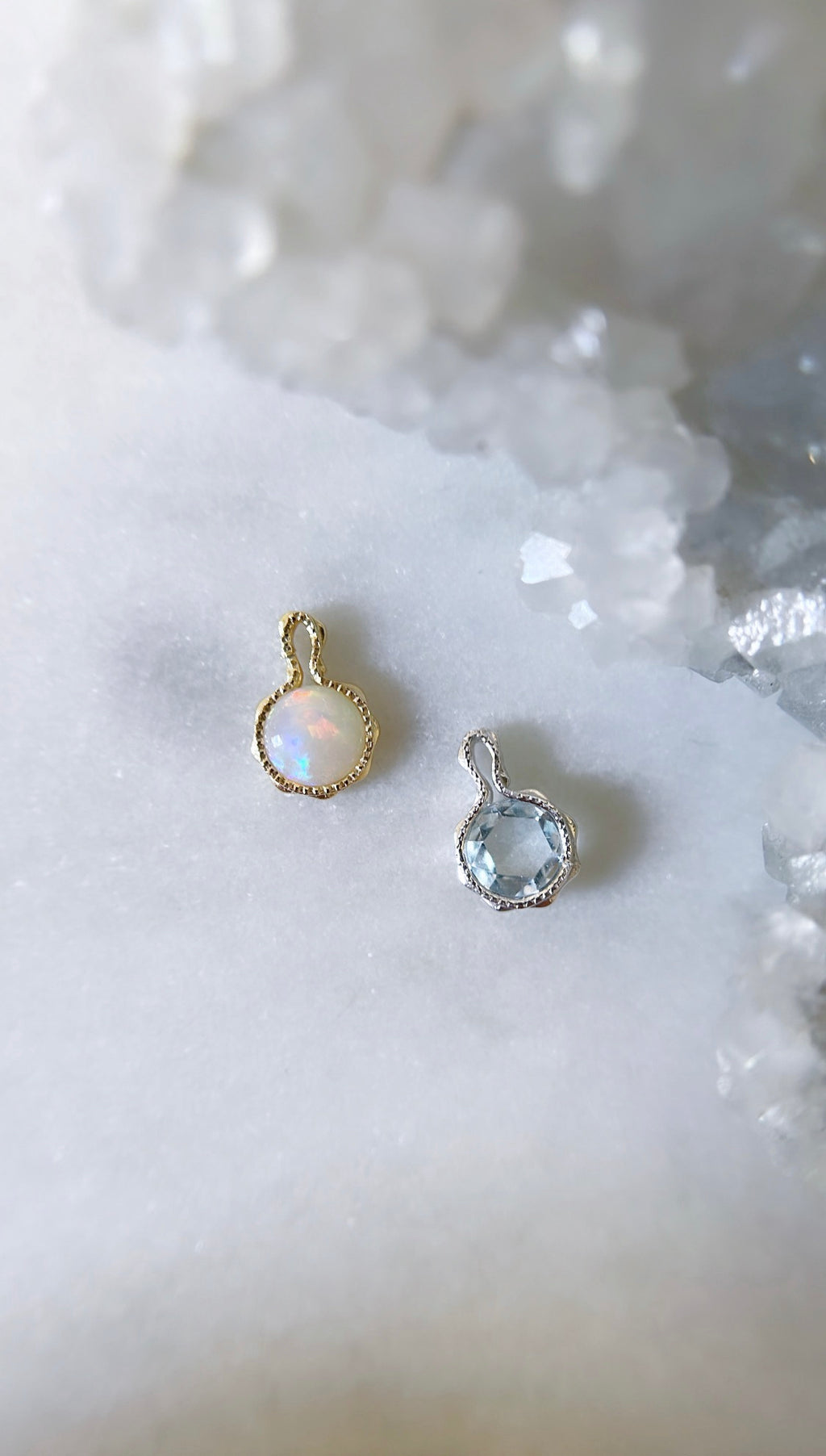 Opal and aquamarine birthstone charms for personalised necklaces on a white background