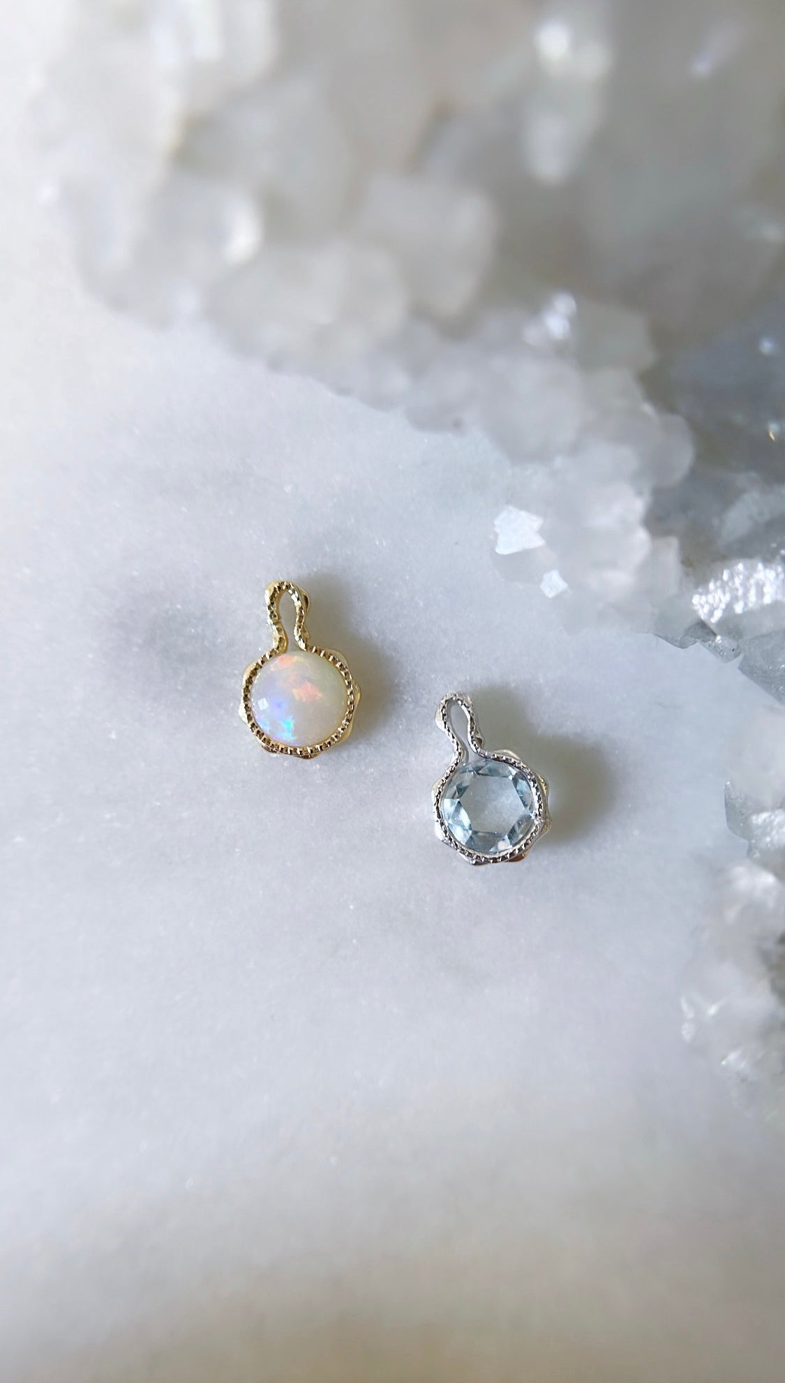 Opal and aquamarine birthstone charms for personalised necklaces on a white background