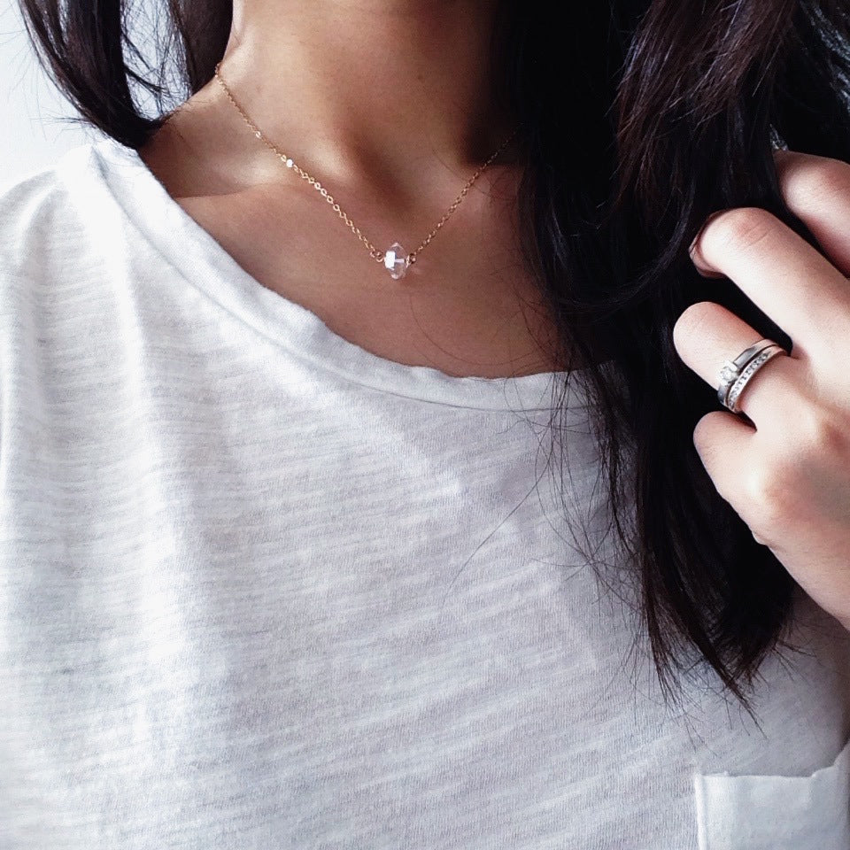 A model wearing a minimalist Quartz Point Diamond necklace in 14kt gold filled