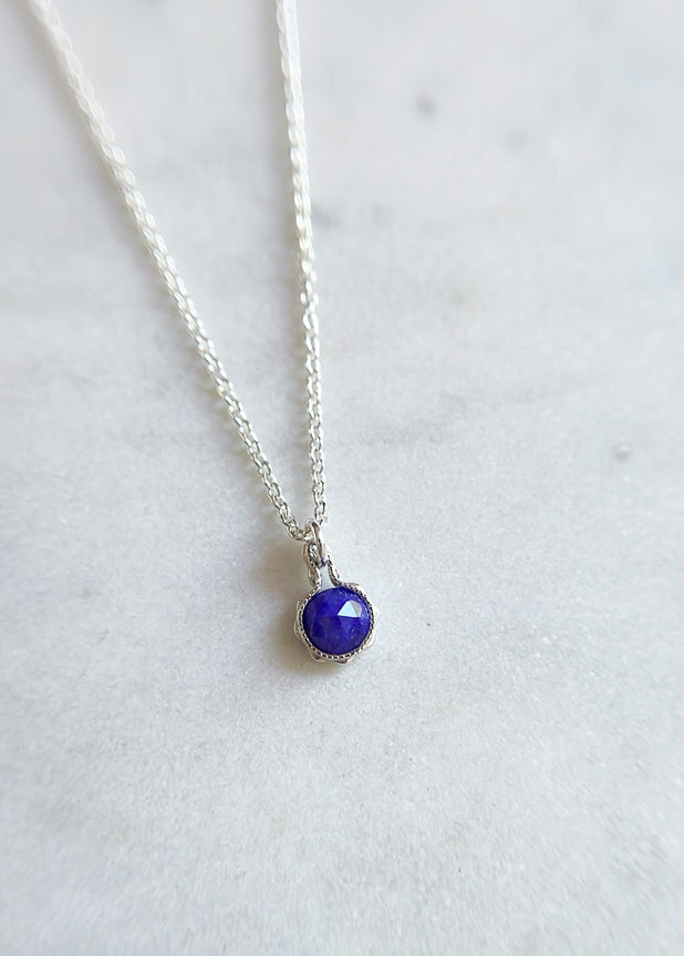 Sterling silver necklace with a round blue sapphire pendant