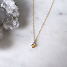 A faceted citrine gemstone pendant on a fine gold chain