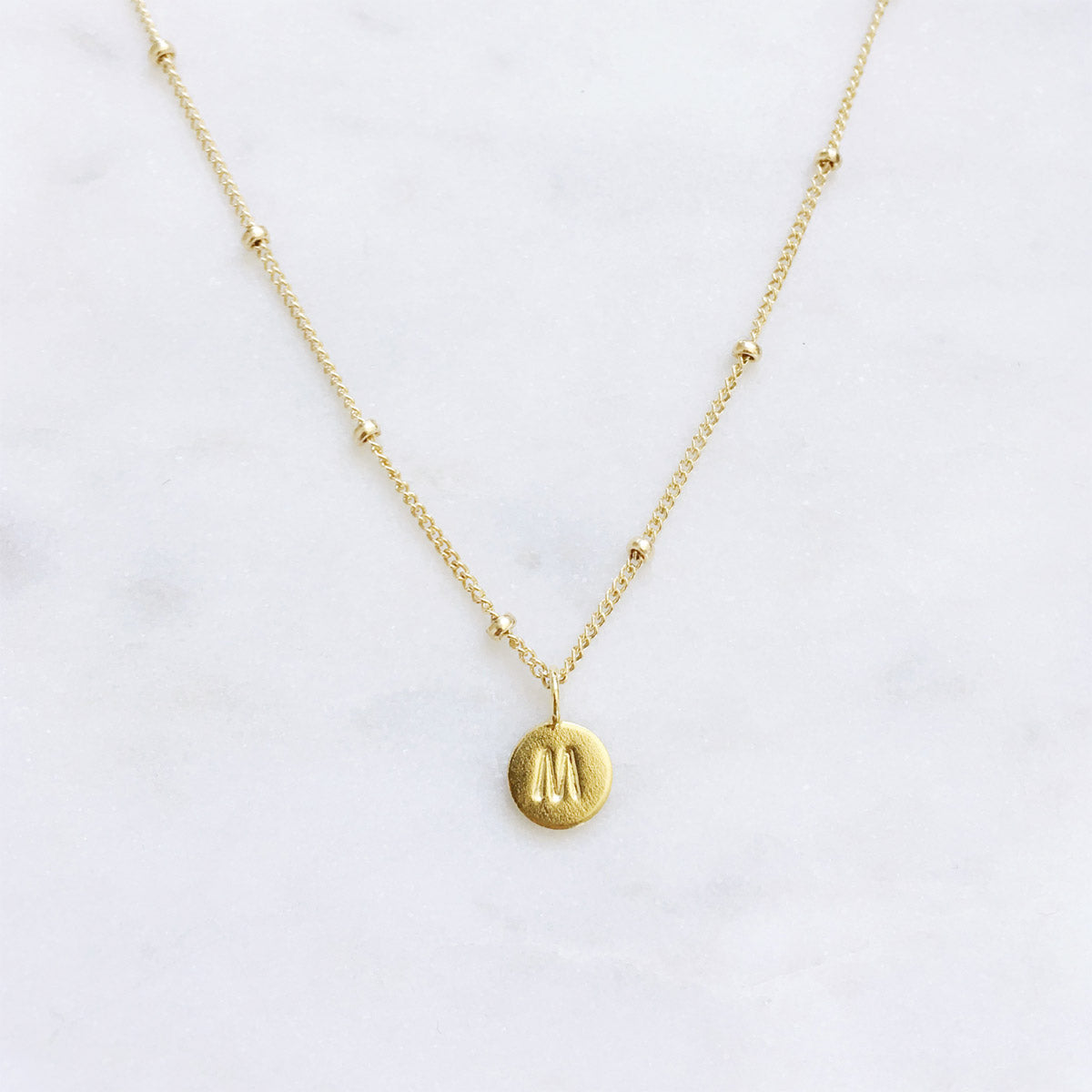 Personalised gold initial necklace with a hand stamped letter on a minimalist 14k gold filled chain, handmade in Australia