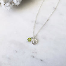 August birthstone necklace with green peridot pendant and an initial pendant tag