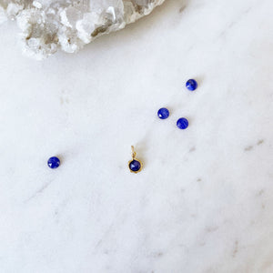 a round rose-cut blue sapphire pendant in gold surrounded by blue sapphire gemstones