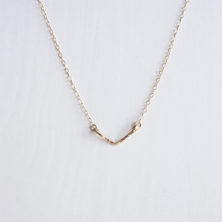 A dainty hand hammered gold chevron necklace