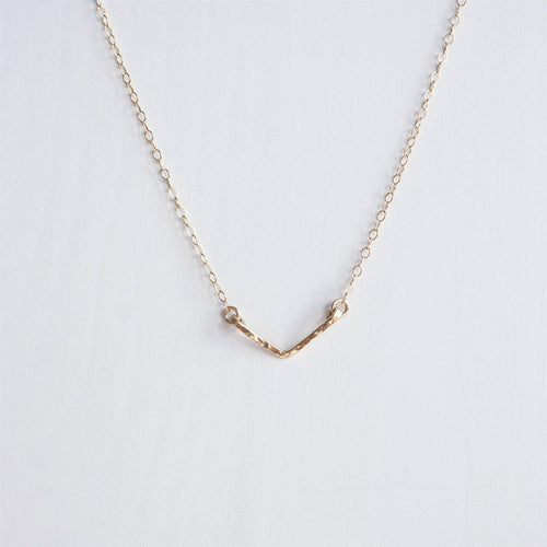 A dainty hand hammered gold chevron necklace