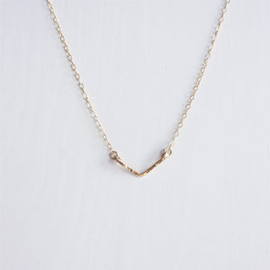 A dainty hand hammered gold chevron necklace