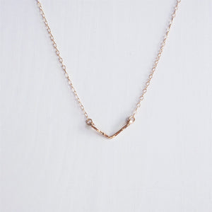 A minimalist rose gold hand hammered chevron necklace