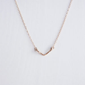 A minimalist rose gold hand hammered chevron necklace