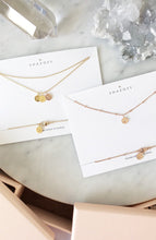 Minimalist necklaces with personalised initial pendants with their blush pink box packaging, jewellery designed and handmade in Australia