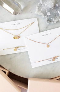 Minimalist necklaces with personalised initial pendants with their blush pink box packaging, jewellery designed and handmade in Australia