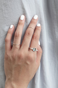 Hand wearing 2 thin delicate midi sterling silver rings and a silver labradorite ring
