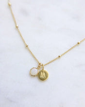 A handmade Australian white opal birthstone necklace with an initial pendant in gold on a gold satellite chain