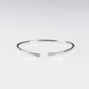 A dainty sterling silver ring band with open ends 