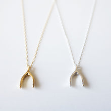 Minimalist fine gold and silver wishbone necklaces placed side by side